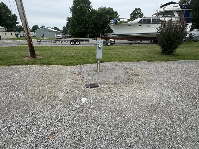Power pedestal and water spigot at a gravel site, boat storage yard behind
